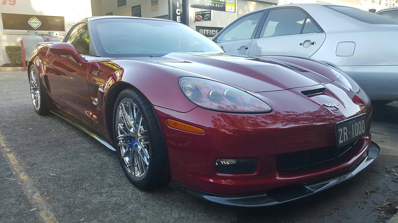 Front of red Corvette ZR2 in auto shop for detailing