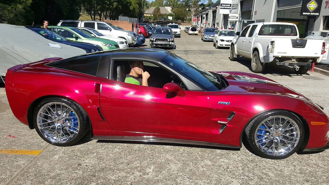 Bodytech member in driver seat of red Corvette ZR5