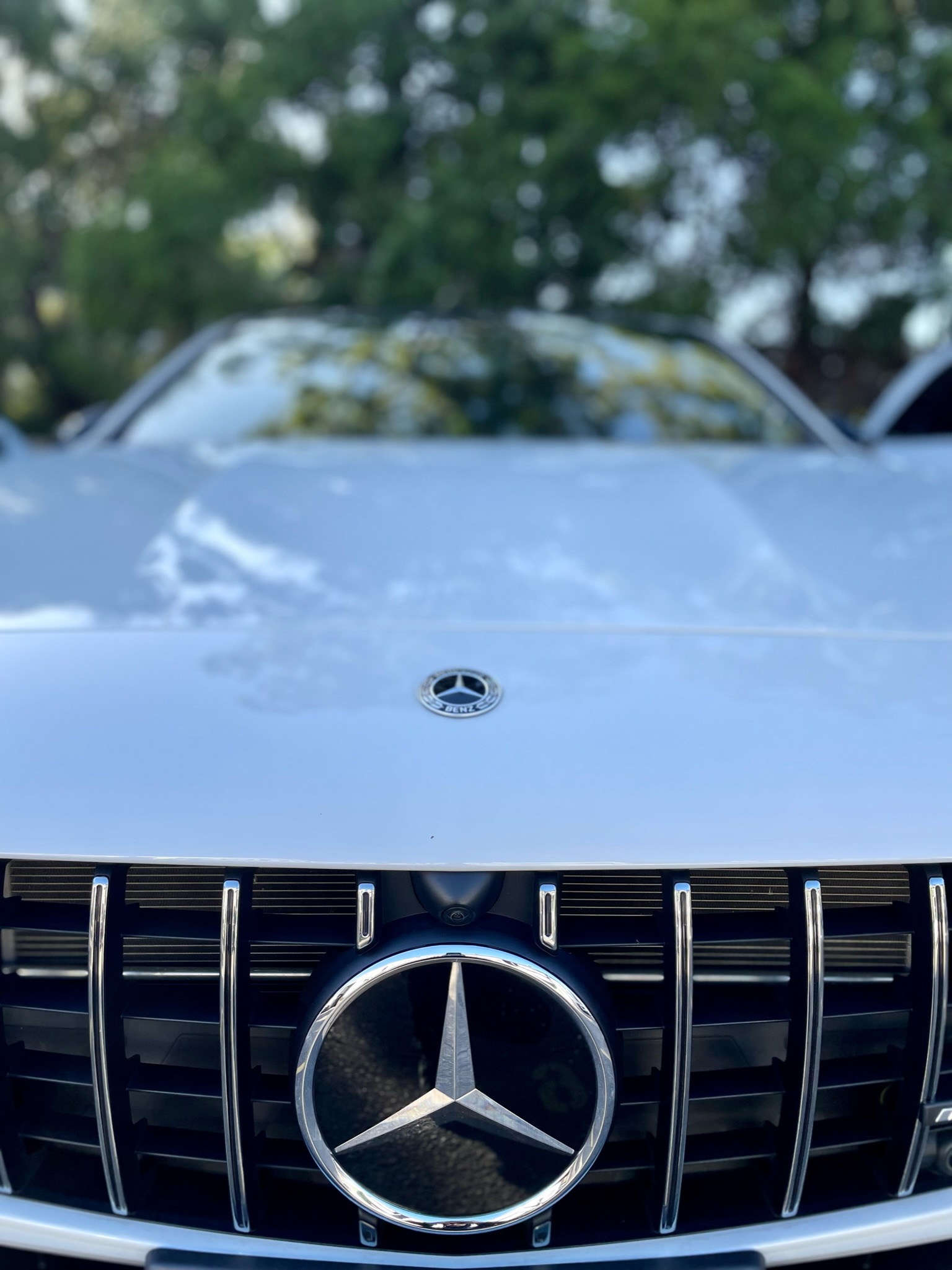 White Mercedes Benz front hood close up